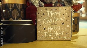 Luxury gift boxes and the Christmas tree decorated with snow, shining lights, golden feathers, carnival-style Christmas tree toys. Buying presents for family in store, holiday shopping in trade center