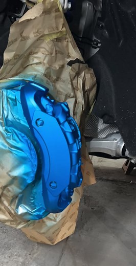 Inspecting a Blue Porsche Brake Caliper in Detail