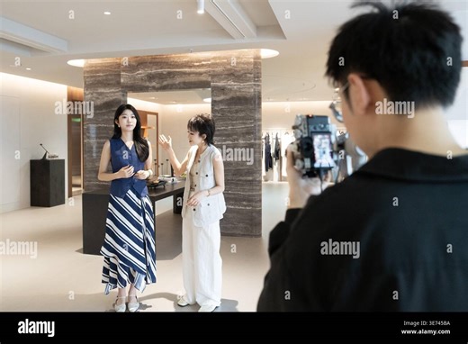 **CHINESE MAINLAND, HONG KONG, MACAU AND TAIWAN OUT**A merchant promotes new summer clothing via short video in Qingsheng Garment Block, known as 'China No.1 Garment Street', in Hangzhou, east China's Zhejiang Province, 9 April 2026. (Photo by Imaginechina/Sipa USA Stock Photo - Alamy