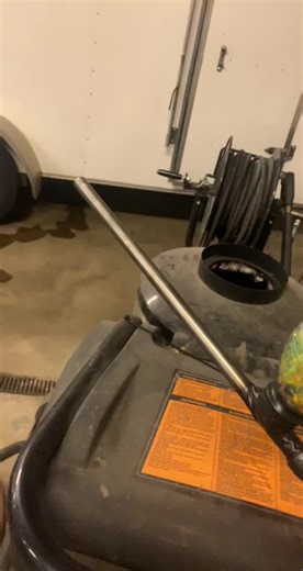 Pressure Washer Cleaning a White Trailer in Workshop