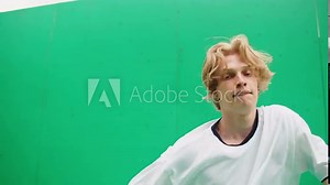 Young man dancing hip hop. Modern dance choreography. Professional breakdancer training on green background, dancer showing dance movings outdoor. Musical video.