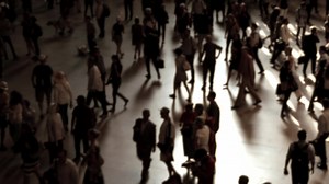 Crowds of people commuting in the city crossing street in rush hour traffic