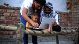 Cheerful Indian family using laptop together at home.