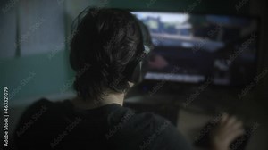 Boy teen play a computer game at home. online video game technology concept. Boy teen play blur shooter video game on a mouse with a keyboard. gambling addiction from video games