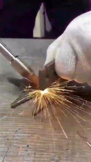 professional worker using handheld laser welding machine on metal