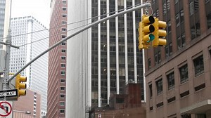 New York City Water street crossroad, yellow traffic light, transport road intersection, United States. NYC Lower Manhattan, downtown financial business district. Highrise skyscrapers. One way sign.