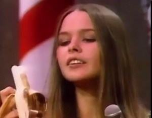 An upset Michelle Phillips eating a banana during the Mamas and the Papas performance of 'California Dreaming' on the Ed Sullivan Show because they had to lip sync, 1967.