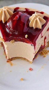 Peanut Butter & Jelly Cheesecake 🥜🍓🍰** **Ingredients:** *For the Crust:* - 2 cups graham cracker crumbs - 6 tablespoons melted butter *For the Cheesecake:* - 4 packages (8 oz each) softened cream cheese - 1 cup smooth peanut butter - ¾ cup sugar - 3 tablespoons flour - 2 teaspoons vanilla extract - ¾ cup heavy whipping cream - 3 eggs - 1 ½ cups warmed strawberry topping or preserves **Instructions:** **Prepare the Crust:** 1. Preheat your oven to 350°F (175°C). 2. Grind graham crackers into c