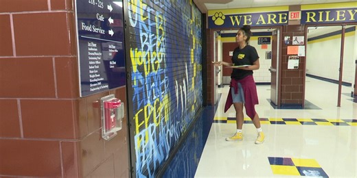 Artist paints words of inspiration on walls of Riley High School