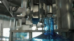 Production. Filling open necks of PET bottles with water. Large empty plastic bottle. 5 Gallon Refillable Bottles Clean Water Bottle On Conveyor.