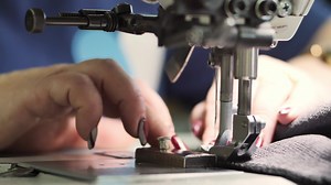 A sewing machine scribbles on slow-mo fabric
