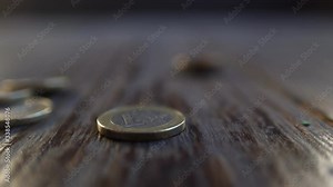 Stack of euro coins falling down on wooden background. Closeup view and soft focus, slow motion