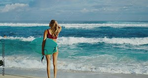 Beautiful young woman at the beach going surfing, surfer beach lifestyle
