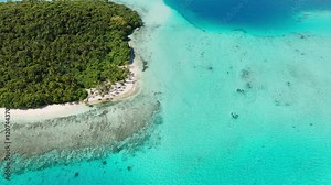 Pristine turquoise waters stretch along the coastline in Tonga, aerial high angle overview of fringign reef and sandy beach atolls