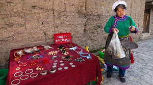 中国の村でアクセサリーや地元の品を売る女性