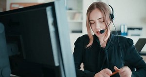Female customer service executive talking through headphones while sitting in corporate office