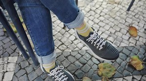Woman's feet under a table outside cafe or restaurant making a waiting gesture. Female waiting as her legs and feet moving impatiently and nervously. Romantic date or meeting or wanting to be served