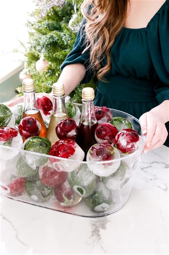 These flower ice balls are one of my favorite ways to keep drinks cool for parties, even in winter at Christmastime. And even though it’s Christmas, I still like my drinks icy cold, especially sparkling juice. I know you all love them too, as this is my most viral video of them all! While regular ice is always an option, these Christmas Ice Balls last WAY LONGER as they are so much BIGGER!! (I even have a video timeline showing how they lasted over 24 hours!) I found a clear container and waterp