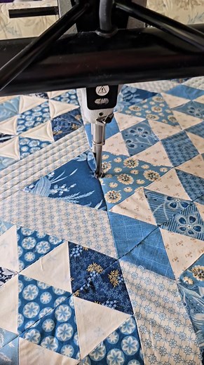 When I machine quilt feathers across two triangles—like I'm doing here on this darling quilt—I like to treat it like one big block! 🪶 I started by using a disappearing ink pen to mark a guideline right through the center of the two triangles. Then I quilted my center feather plumes along that line and built my feather design out from there! I absolutely LOVE hand-guided feathers—they’re so fun and full of personality. 🧡 If you're looking for feather inspiration, be sure to check out my class F