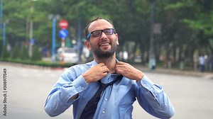 Happy young businessman unbutton shirt in the city, super slow motion