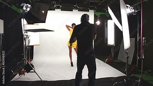 Behind the scenes of a female model being photographed by a male photographer Stock Video