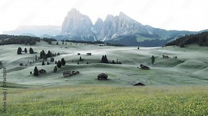 Alpine mountain scenery with cabins and rolling hills at sunrise