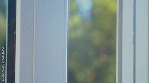 Repair and adjustment of a plastic window. The hands of craftsmen adjust the mechanism of a plastic window with a special tool. Close-up.