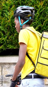 African delivery man with backpack arriving at the entrance of a house at delivery destination