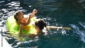 Mom with children swimming in the pool. Splashing water and having fun. A girl and a boy are swimming and playing in the water. Mother and son happily rest and bathe. Swim in the pool. Lead a healthy