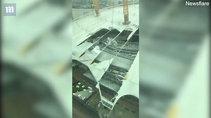The O2 Arena dome seen with a massive tear as high winds slam London