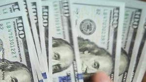 Hands count bills money: they shift dollars on a wooden table, flip through bills. One hundred dollars. A stack of $ 100 bills in close-up. Finance, economy, financial planning, economics, savings.