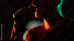 Hipster guy sings on stage in smoke. Slow motion. Music, Sound, Band, Concept.