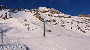 Anzere, Switzerland: Ski lift in the Anzere ski resort followed by a drone in the Swiss alps on a sunny winter day. Shot as a hyper lapse video