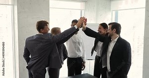 Friendly multiethnic team employees of diverse age gender unite hands in high five sign excited with achieving common goal. Happy teammates succeeded in teamwork celebrate triumph join palms together