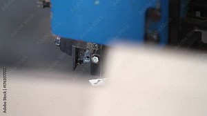 Manufacture of cardboard boxes. Stapling the carton with staples on the machine.