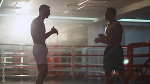Kickboxing, man boxers train in sparring, they performs strikes with their feet, training day in the boxing gym.
