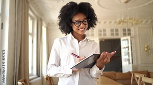 A female manager with glasses for a computer uses a tablet works in an office coworking space, prints a message