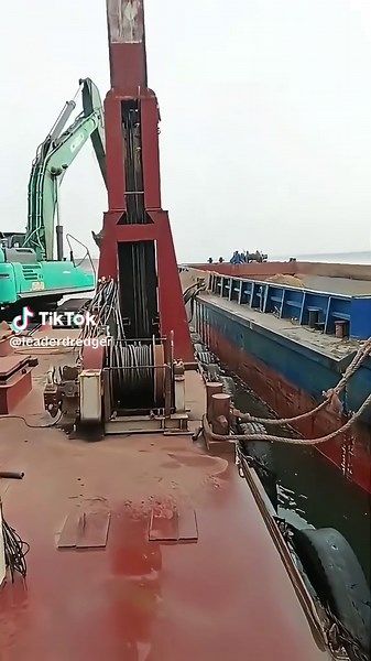 Floating excavator barge = river dredging