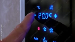 Video 4k. Mens sets temperature of air conditioner with her finger on electronic panel built into wall of room. Modern room climate control systems.