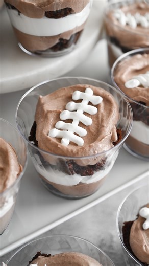 Game day calls for a dessert that’s easy and made with ingredients you can count on from @hyvee 🏈🍫 These football brownie pudding cups are simple to make, fun to serve, and perfect for feeding a crowd on game day! #Ad #HyVeePartner #HyVeeBigGame RECIPE -1 box fudge brownie mix, prepared according to box instructions in 9x13-inch pan -Two 3.4 ounce boxes instant chocolate pudding mix -3 ½ cups cold milk -One 16-ounce tub whipped topping, divided Remove the brownies from the pan and cut into ½ i