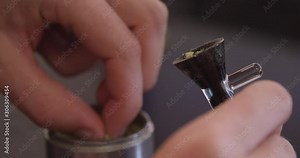 Close Up - Cannabis is packed from a grinder and into a bong bowl - shot on RED
