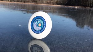A Frisbee Goes the Distance While Gracefully Rolling Across a Frozen Pond in Maine