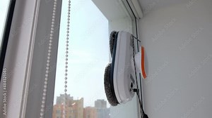 Robot window cleaner work on dirty window. Cleaning the house with smart devices. Automatic vacuum robots for cleaning windows, an assistant for the home
