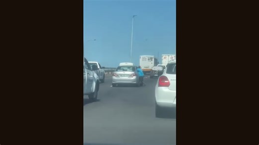 Video: Smash and grab suspect clings to moving car