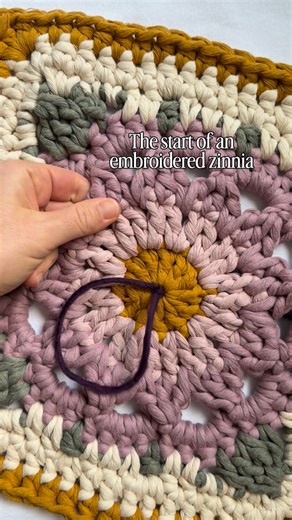 Caroline Langford - Floral Fiber Artist on Instagram: "My first embroidered piece in too long, and my first zinnia ever 🤩 Go to my stories to see the inspo behind this piece and where I’m hoping to go with it! Square pattern is my Radiant Zinnia pattern 🌼 Embroidery techniques in my Embroidered Floral Granny Squares Course ✨ Love always, Caroline #thehappyhomecollective #crochetersofinstagram #floralgrannysquare #flowercrochet #floralembroidery"