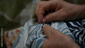 The work of the seamstress sews clothes and threads the fabric.