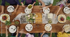 Big Indian Family Lunch Table: Top Down Elevated View at a Family and Friends Celebrating Outside at Home.Group of Children, Adults and Seniors Eating, Passing Traditional Dishes of Curry and Naan