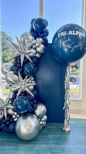 Celebrating the newest inductees of the Tri-Alpha Honor Society at Coastal Carolina University! 💙✨ We designed this bold navy silver balloon installation to elevate their ceremony. Honored to help make this milestone moment extra special. 🎈 Tri-Alpha Honor Society Induction 📍 Coastal Carolina University #trialpha #firstgen #CCU #CoastalCarolinaUniversity #BalloonArtist Balloon stylist. Event decor. Holiday party. | POP Glam Balloon Company