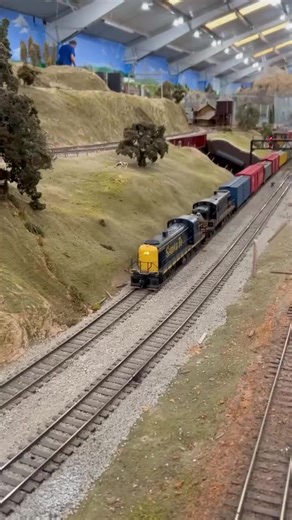 A pair of midcentury freight trains look right at home on our sprawling O Scale layout, with a pair of ALCos on point for the lower loop train and a quartet of EMDs leading the upper. Which is your favorite? #modeltrains #trains #modelrailroad #modelrailroading #scalemodel #oscale #oscaletrains #museum #bayarea | Golden State Model Railroad Museum