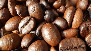 The world of coffee with this captivating close-up, revealing the intricate spectrum of dark brown tones and lustrous finishes on roasted beans, each telling a story of unique roasting techniques.